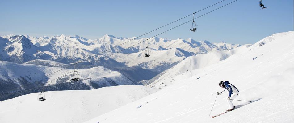 A skier descends a snowy slope