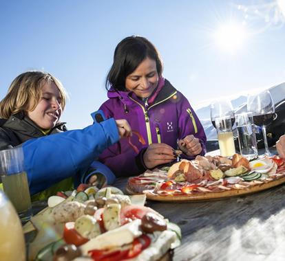 A family in winter clothes is having a snack