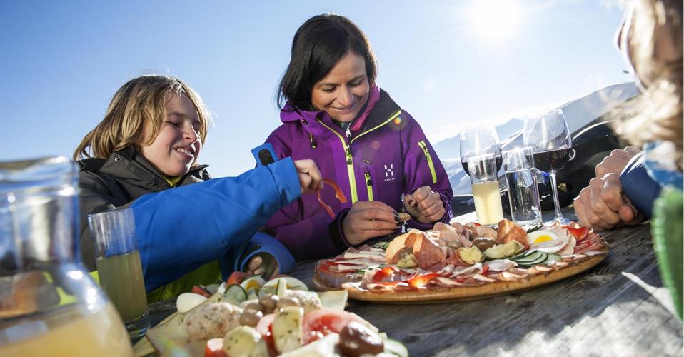A family in winter clothes is having a snack