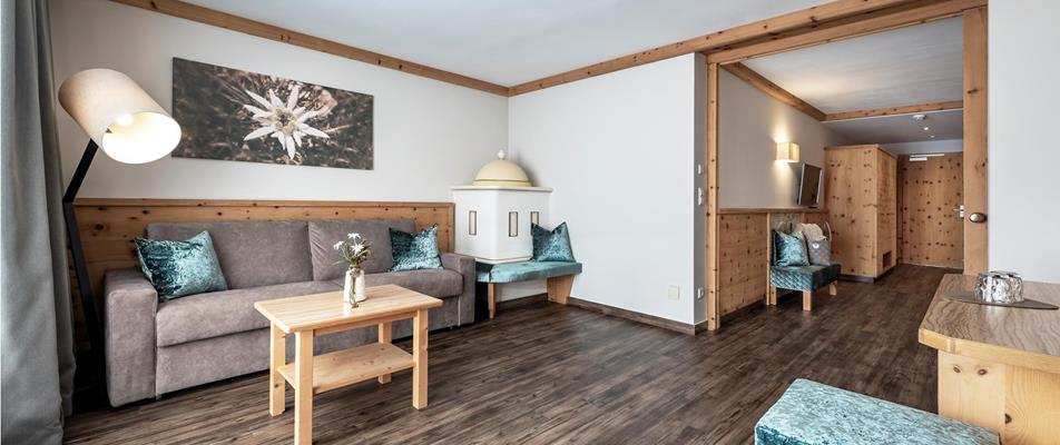 Der Wohnbereich der Suite Edelweiss mit Sofa und Kachelofen