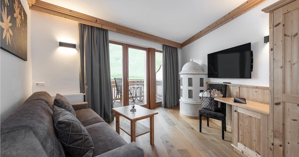 Living room with a balcony and a tiled stove