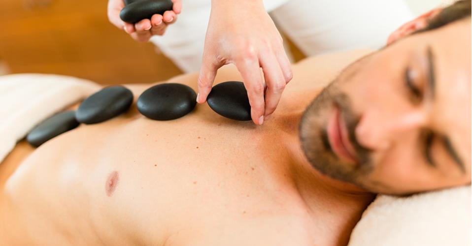 Ein Mann erhält eine Hot-Stone-Massage