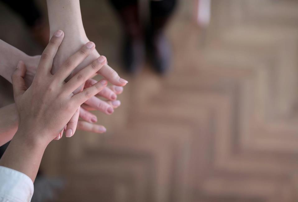 Several hands stacked on top of each other