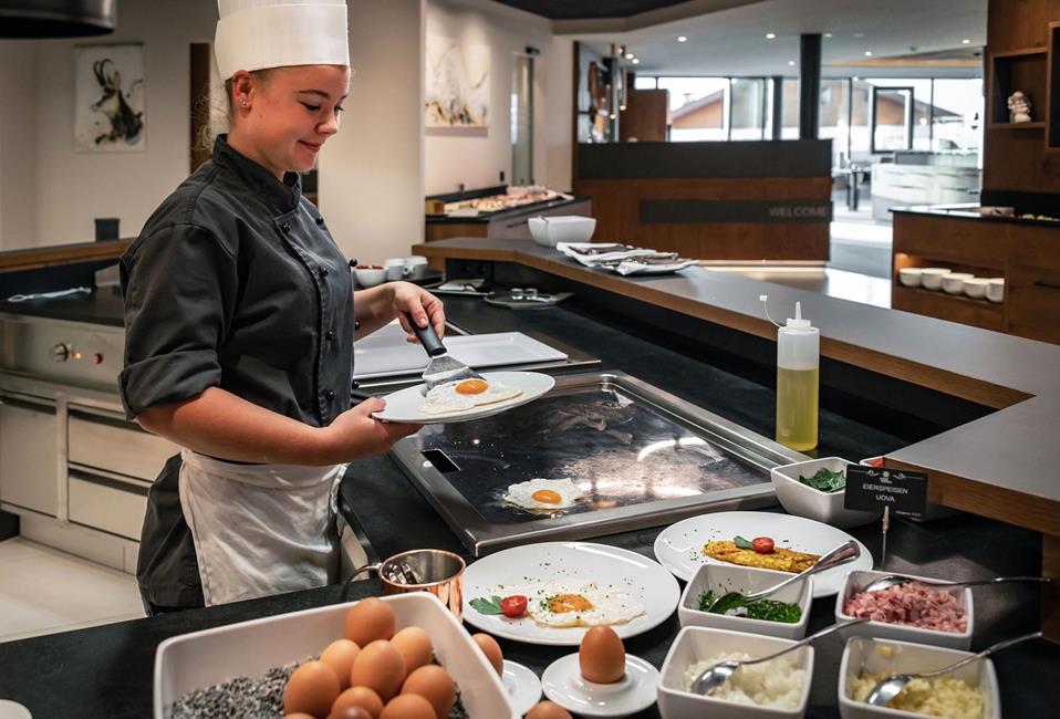 Una cuoca prepara le uova per la colazione