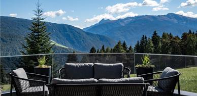 Moderne Terrasse mit Lounge-Möbeln und traumhaftem Panoramablick auf die Südtiroler Bergwelt.