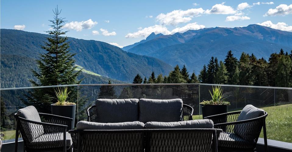 Moderne Terrasse mit Lounge-Möbeln und traumhaftem Panoramablick auf die Südtiroler Bergwelt.