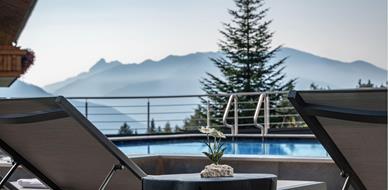 Piscina esterna con lettini e vista sulle montagne