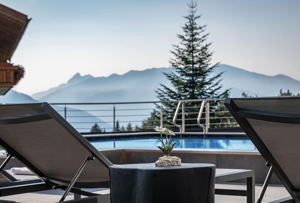 Piscina esterna con lettini e vista sulle montagne