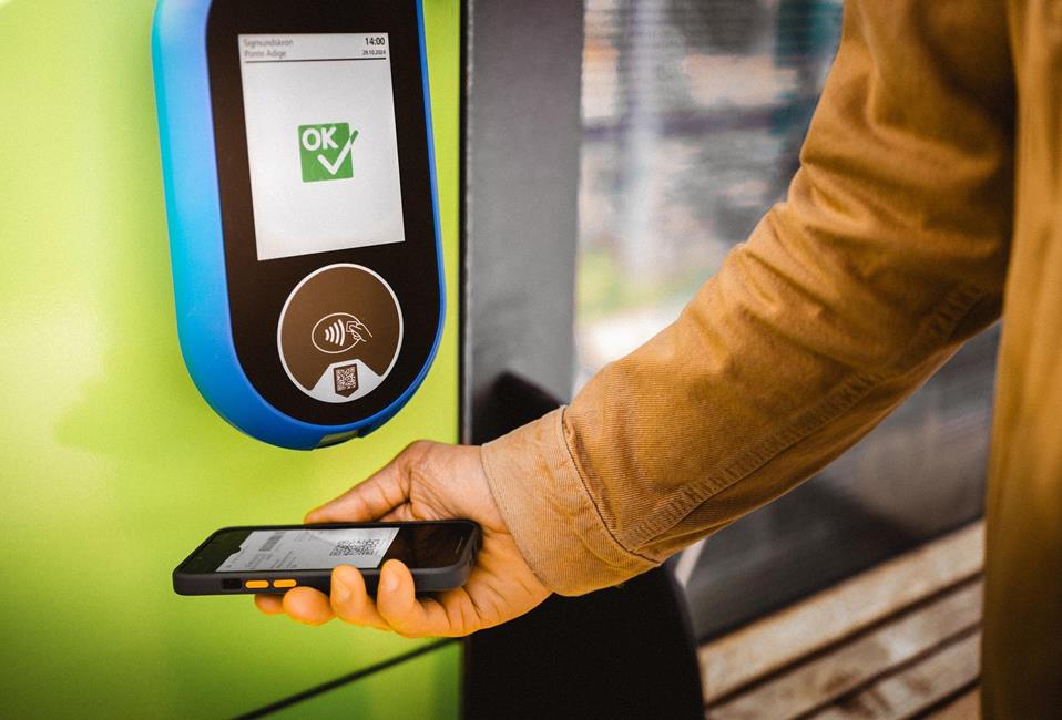 Convalida del biglietto con smartphone su lettore verde, display con conferma “OK”.