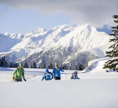 Eine Familie hat Spaß beim Schneeschuhwandern