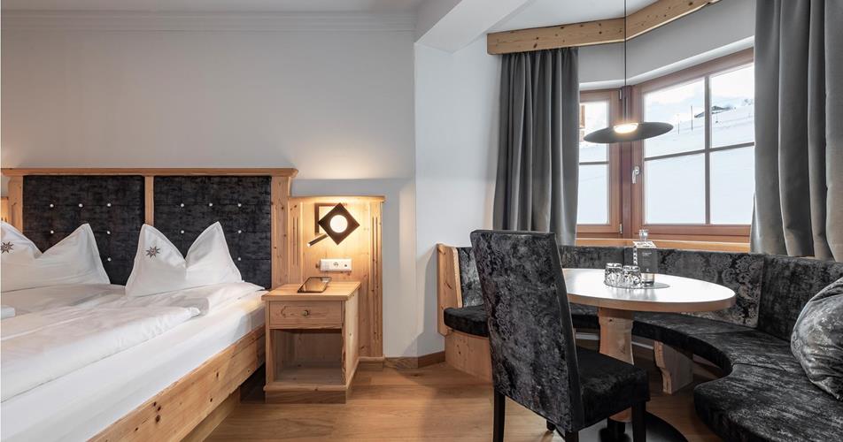 Schlafzimmer mit Doppelbett und Sitzecke in Erkerform